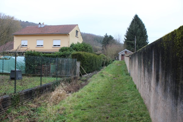 Des contacts abrupts entre les clôtures, les jardins et le cours d'eau.