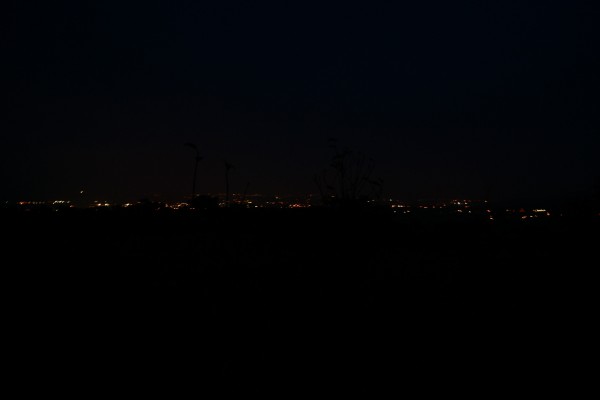 La vallée de la Moselle, depuis les hauteurs de Saulny, plongée dans le noir. Apparaissent alors, comme étirées le long d'une épaisse ligne et dessinant comme un nouvel horizon dans la nuit, les lumières des espaces habités par les êtres humains. La photographie est prise sans dispositif particulier. Elle parvient seulement à capter les points lumineux, plongeant le ciel le fond et les premiers plans dans le noir.